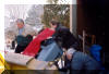 Stansbury Park Service Agency's Bob Shields and SLAS's Roger Butz and Bruce Grim guide the "Big Scope" mount onto the back hoe. 05 FEB 2002 McNeil image