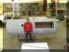 Chuck Hards' companion employee Brian Talbot poses in front of tube for scale. Secondary access hatch visible on right side of tube, output hole next to his shoulder. 16 OCT 2001 Chuck Hards image
