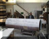 Chuck Hards stands behind the tube which is now completely coated with a very smooth layer of fiberglass (dark color) and half of the gelcoat (white) has been applied. 24 OCT 2001
